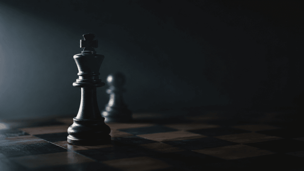 Chess king standing on a dark chessboard