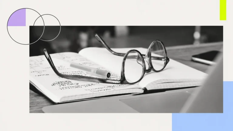Reading glasses resting on an open notebook.