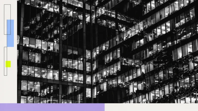 Illuminated office windows against a dark building.
