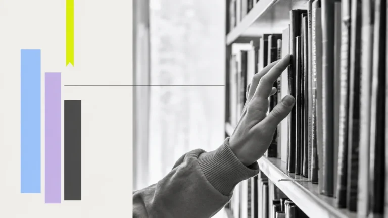 A hand selecting a book from a shelf.
