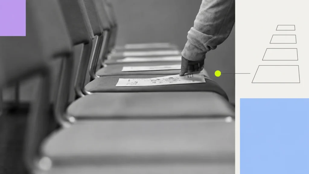 A hand placing leaflets on a row of chairs.
