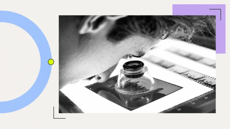 A person examining photographic film through a loupe.